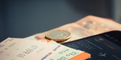 Keliautojas oro uoste planuoja ekonomišką kelionę lėktuvu ir tikrina skrydžio bilieto informaciją.